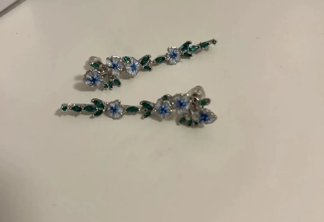 Glossy Blue Floral Dangling Earrings worn by a customer